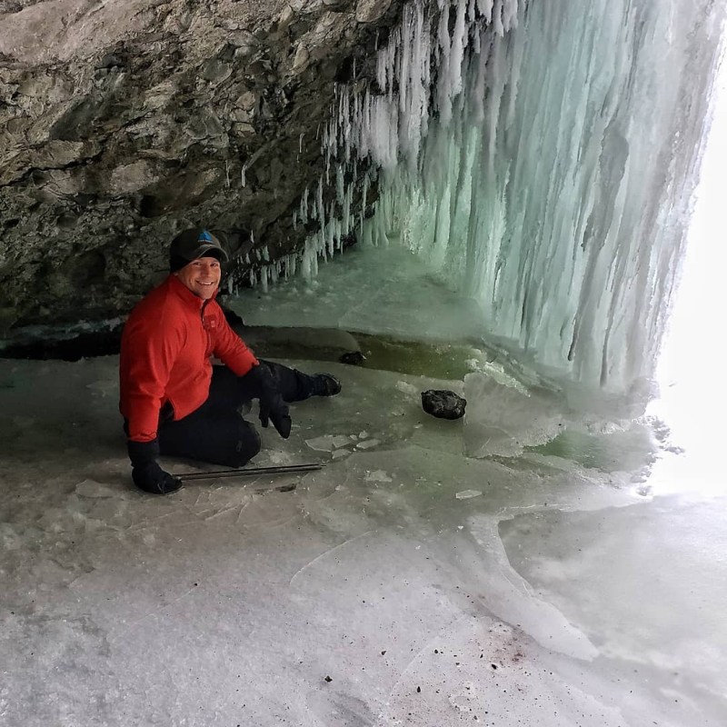 a man and a woman in a red jacket standing in the snow