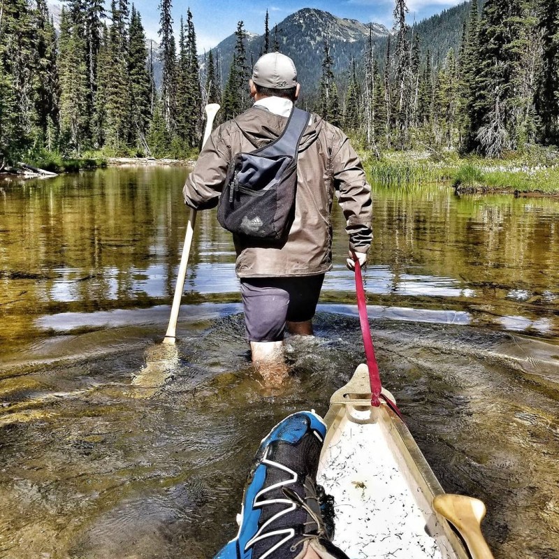 a man standing next to a body of water