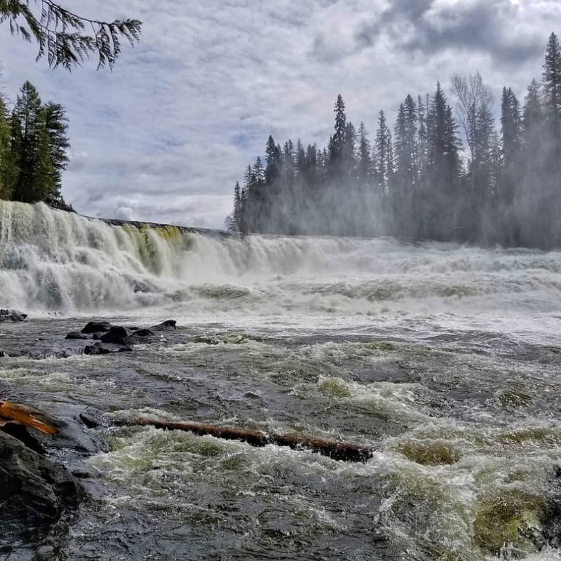 a man standing next to a waterfall