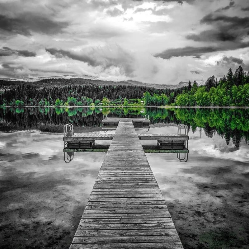 a row of park benches sitting next to a body of water