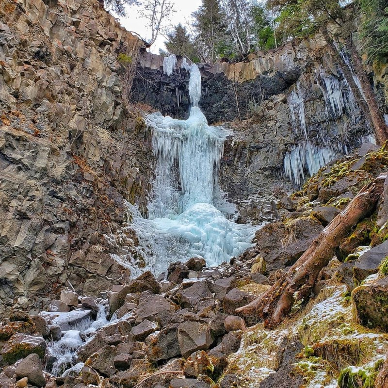 a large waterfall over a rocky cliff