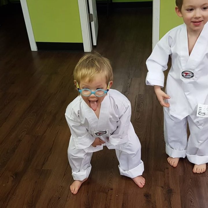 a little boy sitting on a wooden floor