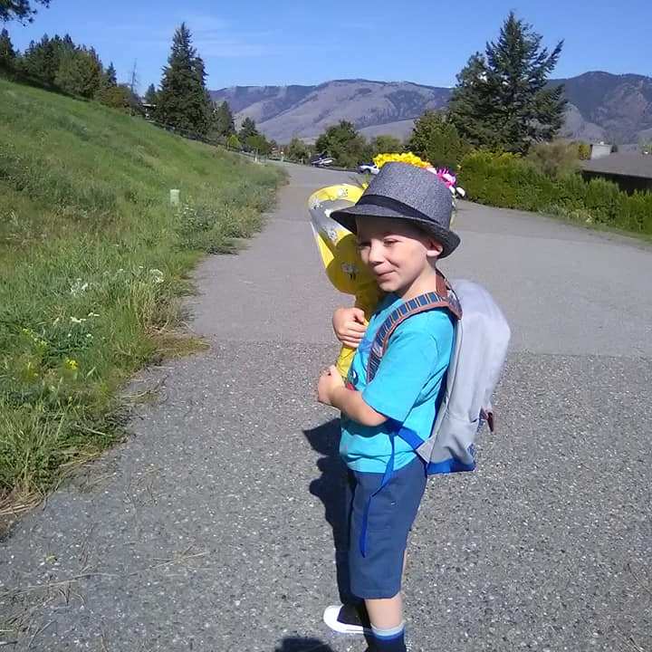 a little boy that is standing in the road