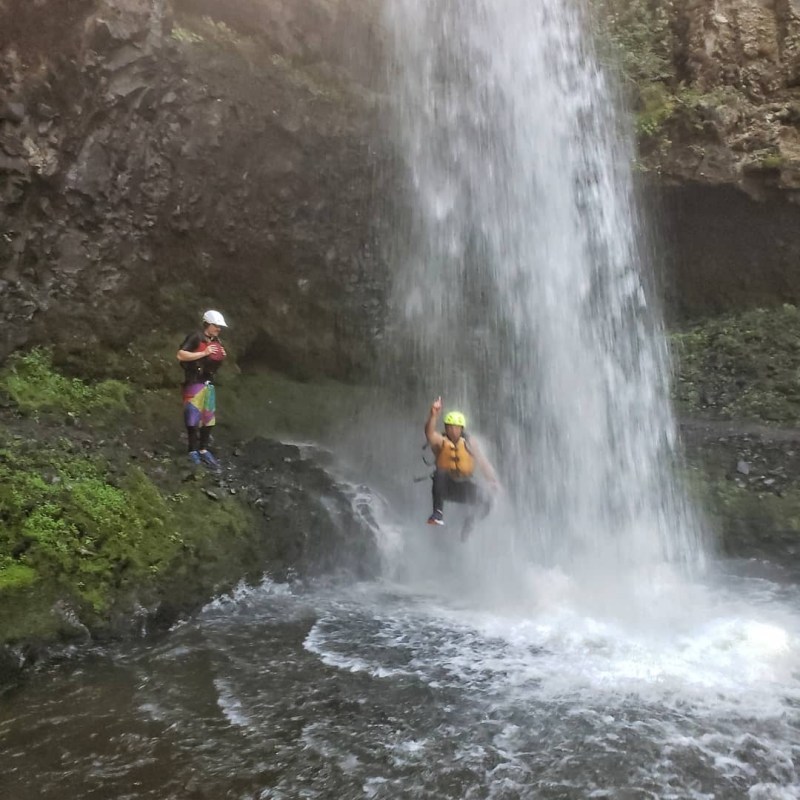 a group of people riding on the back of a waterfall