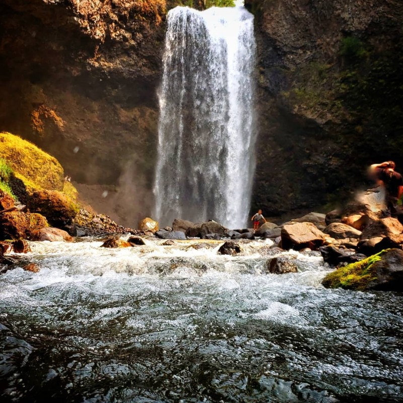 a large waterfall over some water