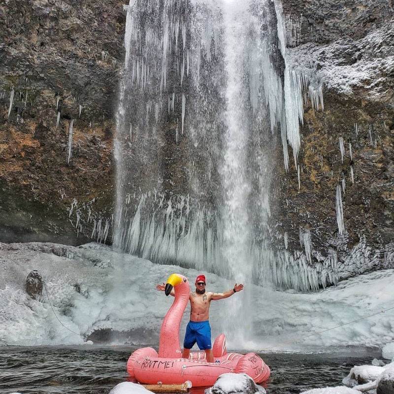 a large waterfall over a fire hydrant covered in snow