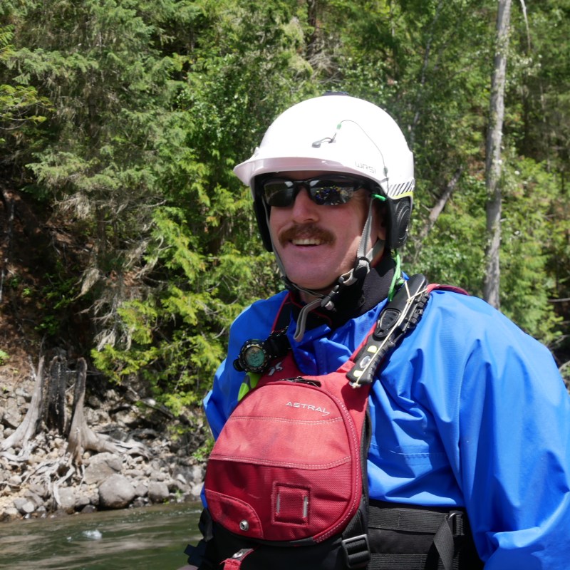 a man standing next to a river