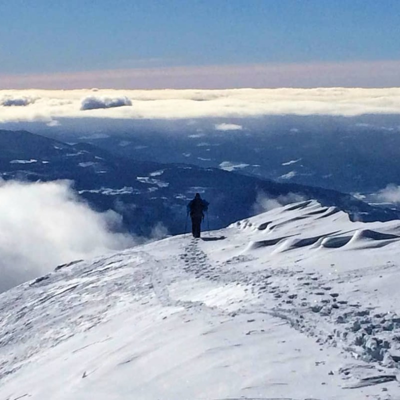 a man riding on top of a snow covered mountain