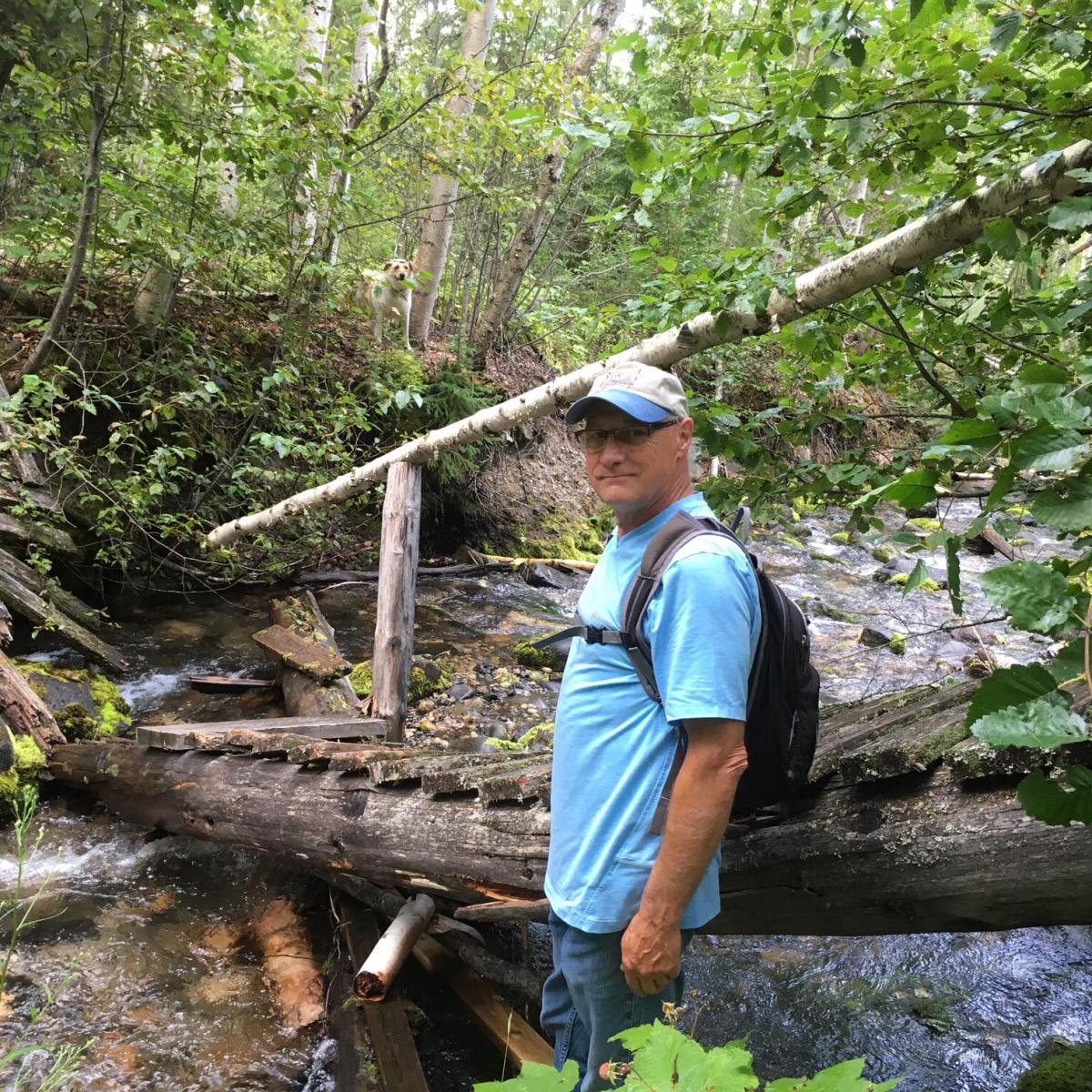 a man standing next to a tree
