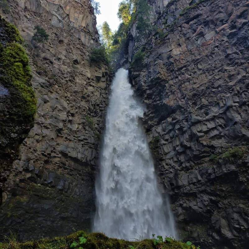 a large waterfall over a rocky cliff