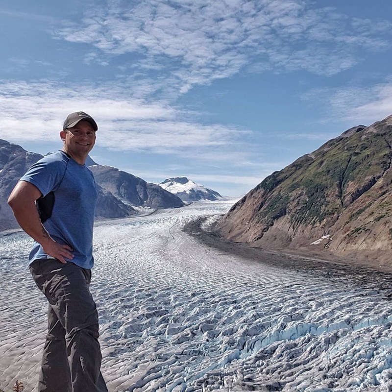 a man standing in front of a mountain
