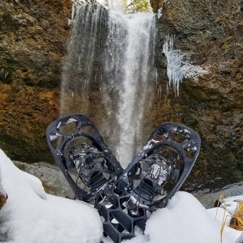 a pile of snow next to a waterfall