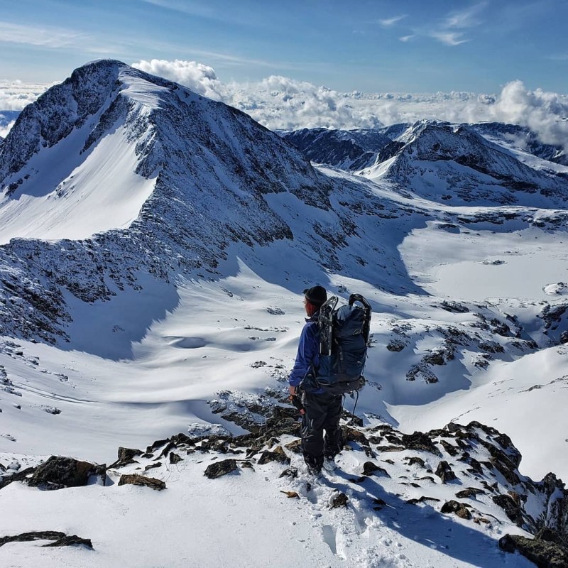 a man standing on top of a snow covered mountain