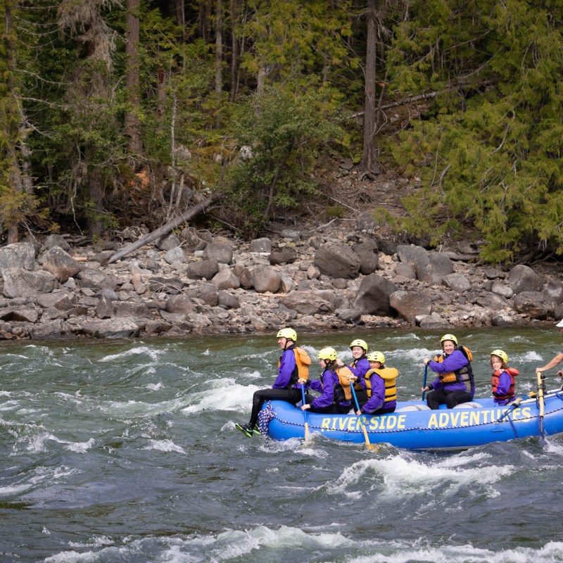 a group of people riding on a raft in a body of water