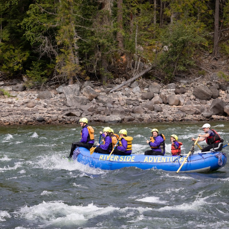 a group of people riding on a raft in a body of water
