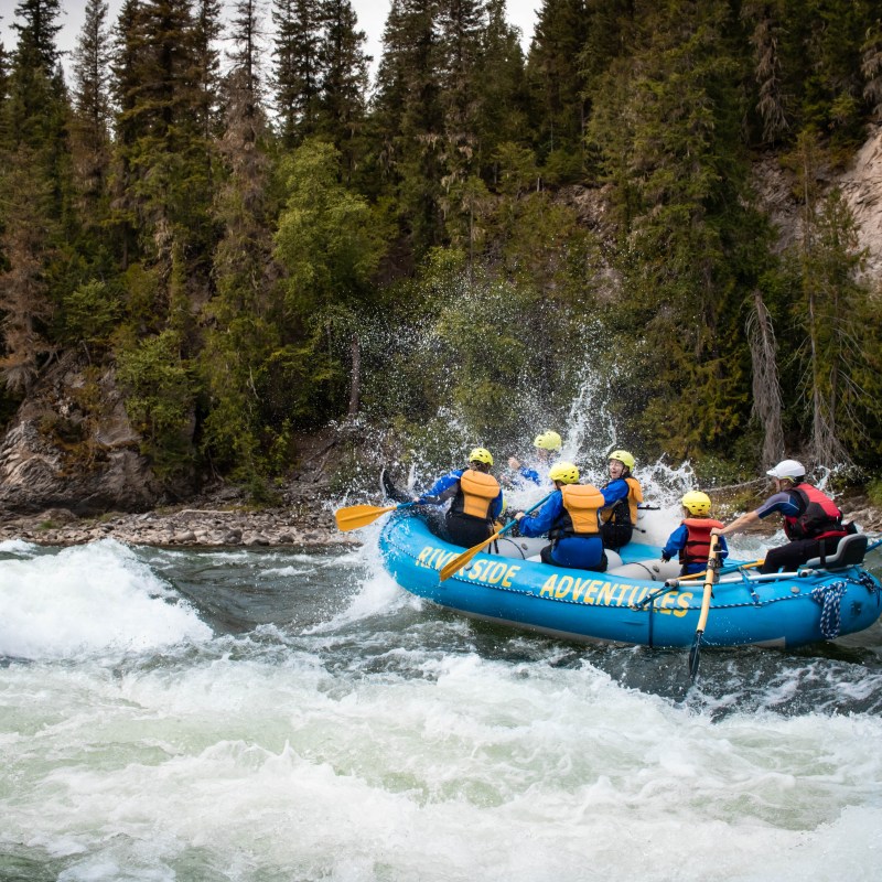 a group of people riding on the back of a boat in the water