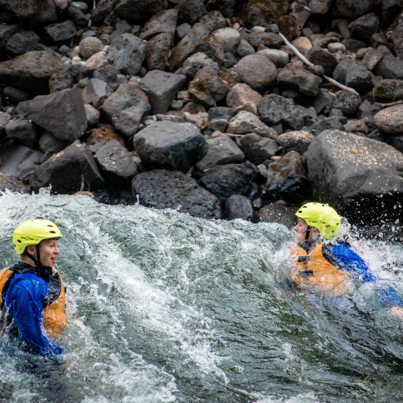 a man riding a wave on top of a rock