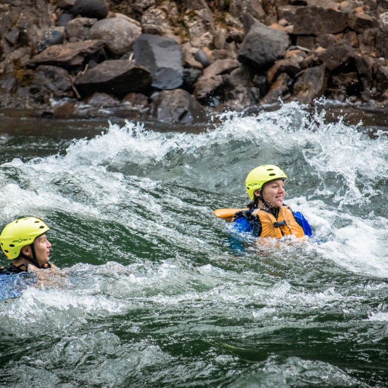 a man riding a wave on a raft in a body of water