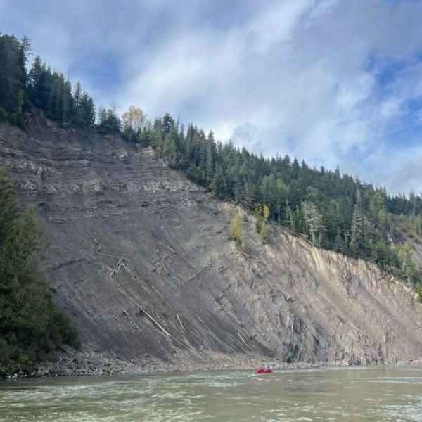 Large landslide on a forested mountainside with river below.